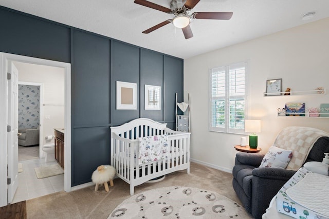 carpeted bedroom with a nursery area and ceiling fan