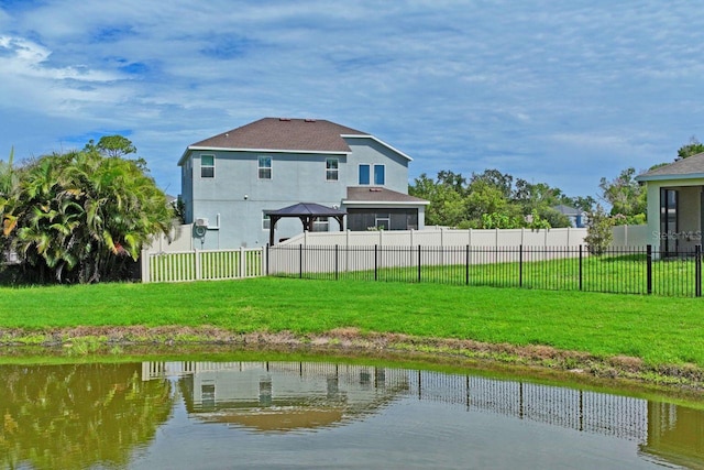 rear view of house with a gazebo, a lawn, and a water view