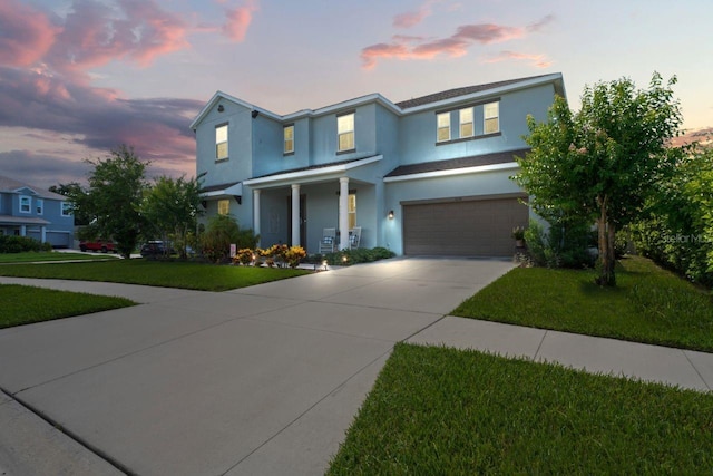 view of front of property with a garage and a lawn