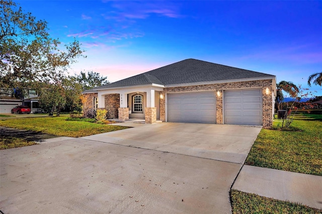 view of front of home with a garage and a lawn