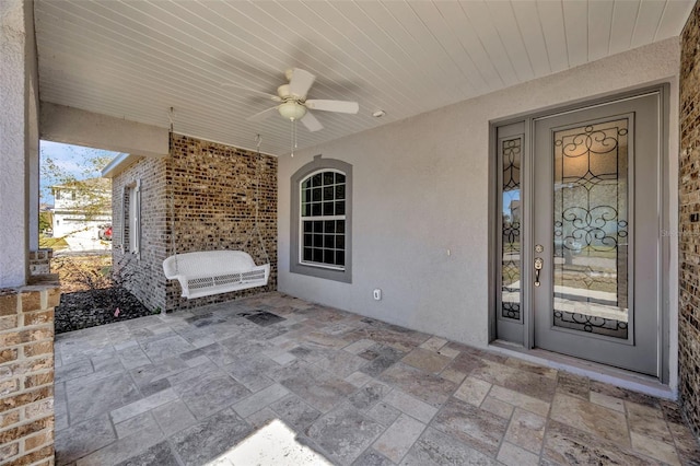 view of exterior entry featuring a patio area and ceiling fan