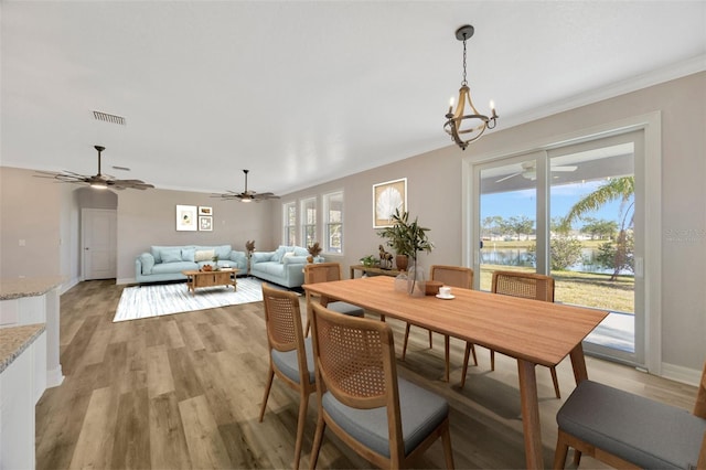 dining room with ornamental molding, plenty of natural light, and light wood-type flooring