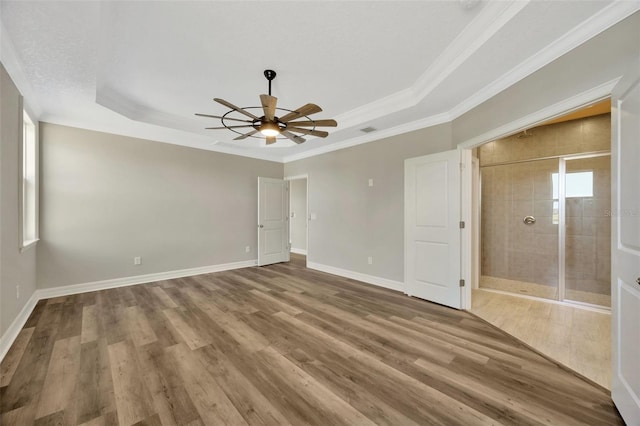 unfurnished bedroom featuring hardwood / wood-style flooring, ornamental molding, and a tray ceiling