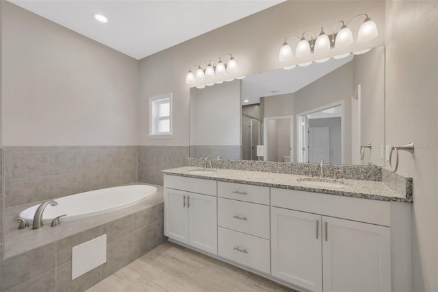 bathroom featuring hardwood / wood-style flooring, vanity, and plus walk in shower