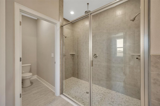 bathroom with an enclosed shower, hardwood / wood-style floors, and toilet