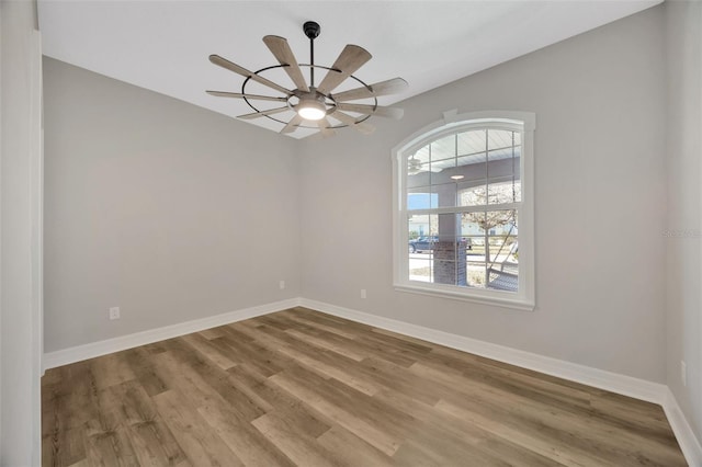 spare room with hardwood / wood-style floors and ceiling fan