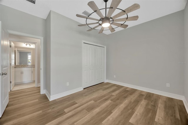 unfurnished bedroom featuring ceiling fan, light hardwood / wood-style floors, and a closet