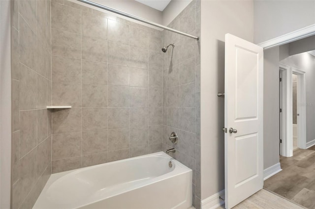 bathroom with tiled shower / bath and hardwood / wood-style floors