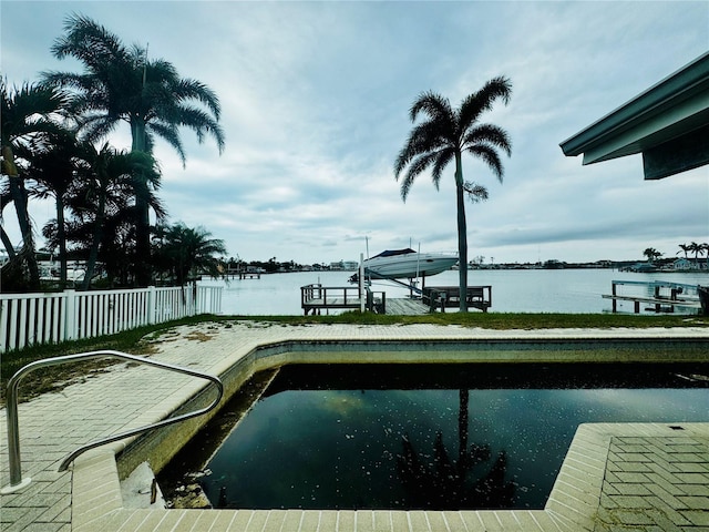 view of pool with a water view and a dock