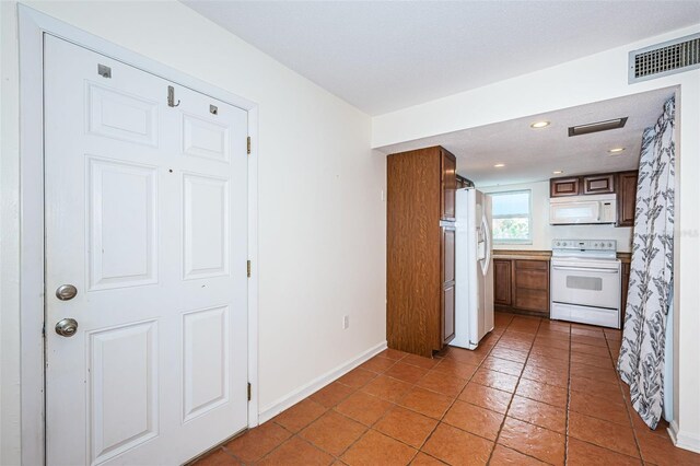 kitchen with tile patterned flooring and white appliances