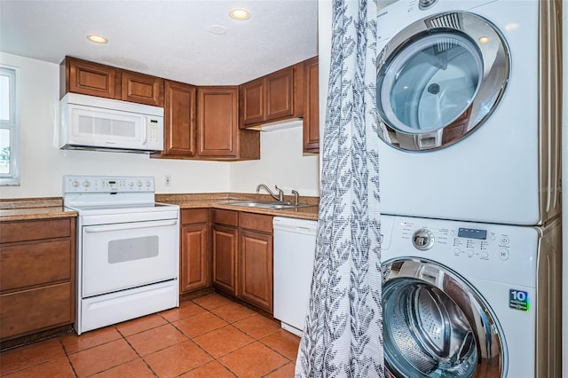 kitchen featuring light tile patterned flooring, stacked washer / drying machine, sink, and white appliances