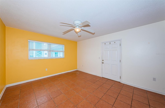 tiled empty room with a textured ceiling and ceiling fan