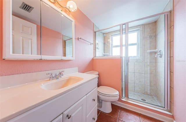 bathroom featuring vanity, toilet, and a shower with door