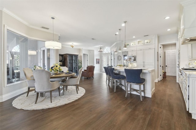 dining room featuring ornamental molding and dark hardwood / wood-style floors