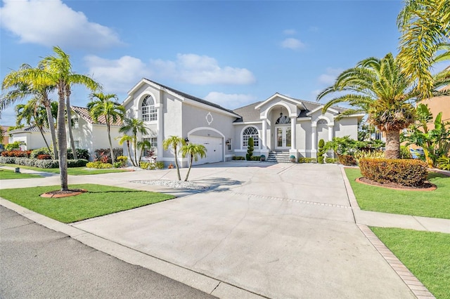 mediterranean / spanish-style home featuring a garage and a front yard