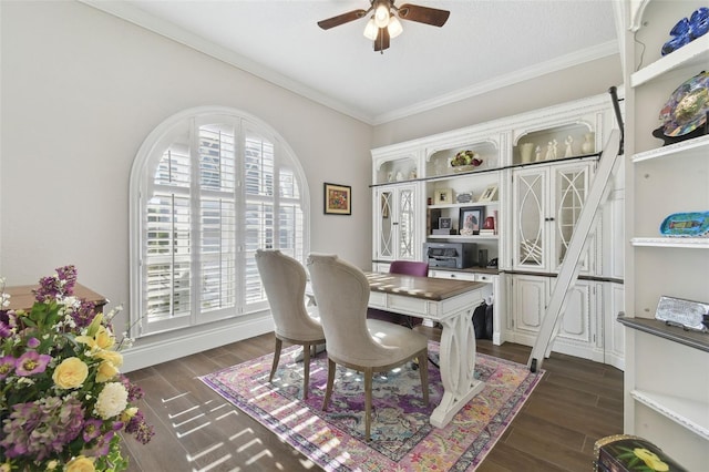 dining area featuring crown molding, dark wood-type flooring, and ceiling fan