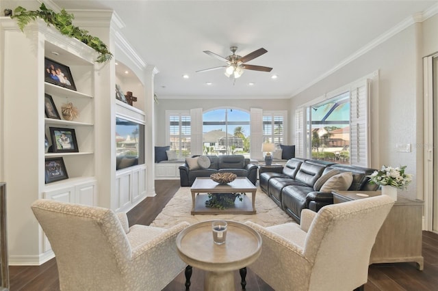 living room with crown molding, dark wood-type flooring, ceiling fan, and built in shelves