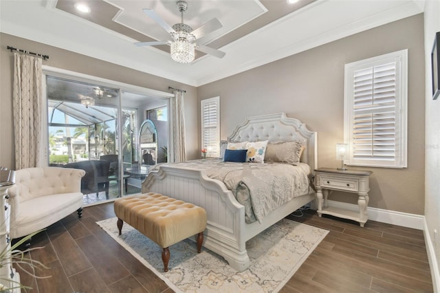 bedroom featuring baseboards, wood finish floors, a tray ceiling, ornamental molding, and access to outside