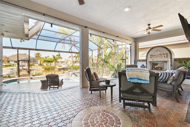 sunroom featuring a water view and ceiling fan