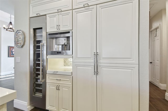 kitchen with dark hardwood / wood-style floors, hanging light fixtures, and white cabinets