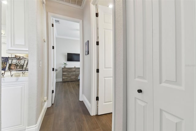 hall featuring crown molding, baseboards, visible vents, and dark wood-type flooring