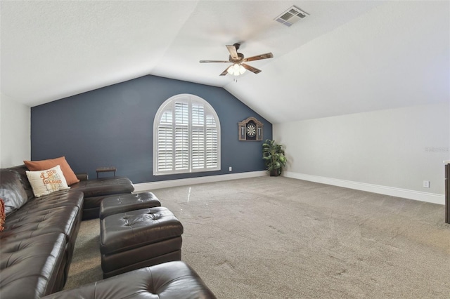 carpeted living room with ceiling fan and vaulted ceiling