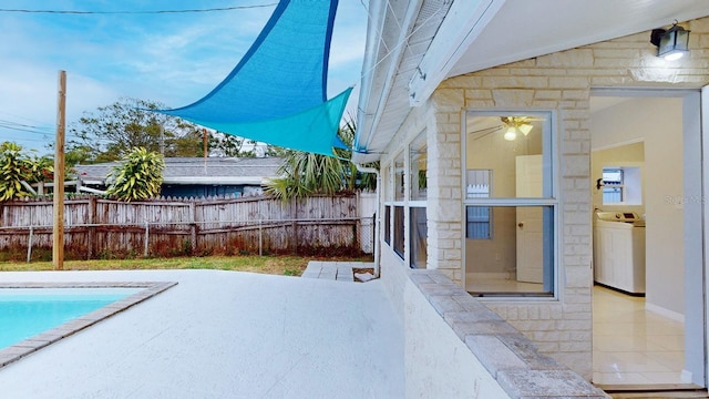 view of pool featuring a patio and washer / clothes dryer