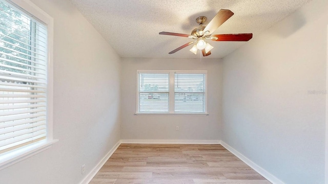 spare room with a textured ceiling, ceiling fan, and light hardwood / wood-style floors