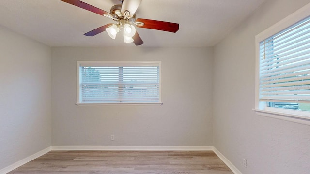 empty room with ceiling fan, light hardwood / wood-style floors, and a healthy amount of sunlight