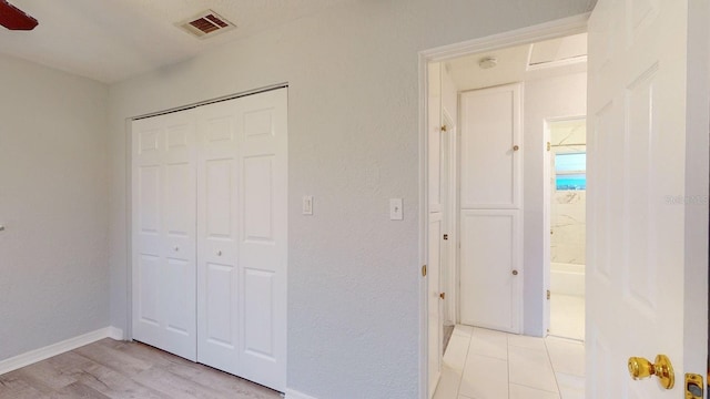 unfurnished bedroom with ceiling fan and a closet