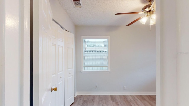 spare room featuring a textured ceiling, ceiling fan, and light hardwood / wood-style floors