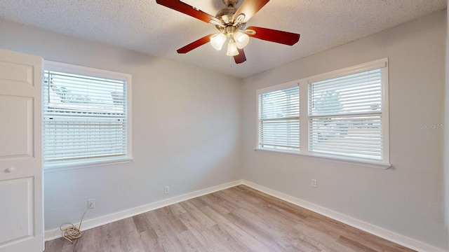 unfurnished room featuring light wood-type flooring, ceiling fan, and a textured ceiling