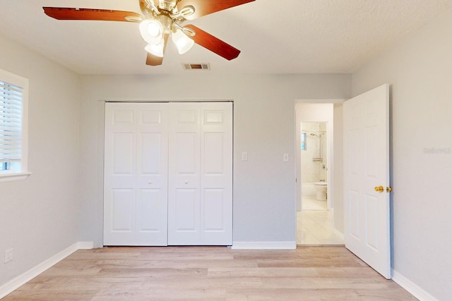 unfurnished bedroom featuring ceiling fan, light hardwood / wood-style floors, and a closet