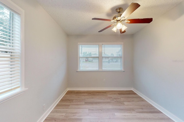 spare room with a textured ceiling, light wood-type flooring, and ceiling fan