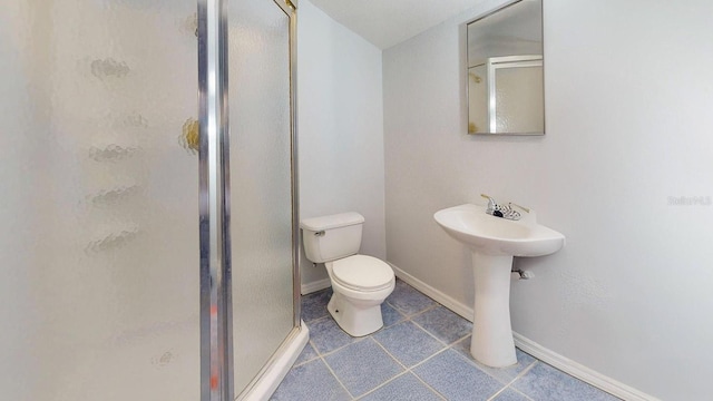 bathroom with sink, a shower with shower door, and toilet