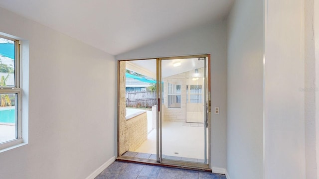 doorway to outside featuring vaulted ceiling