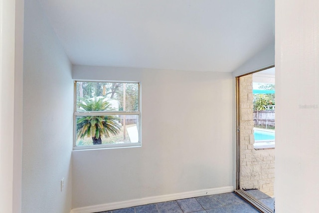 unfurnished room featuring vaulted ceiling