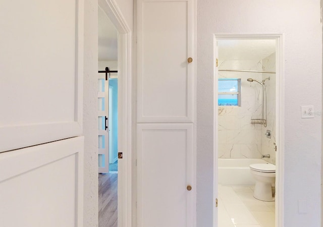 bathroom featuring toilet, tile patterned floors, and tiled shower / bath