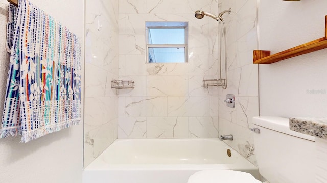 bathroom featuring tiled shower / bath combo and toilet