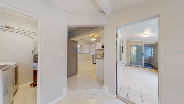 hallway with vaulted ceiling, washer and clothes dryer, and light tile patterned floors