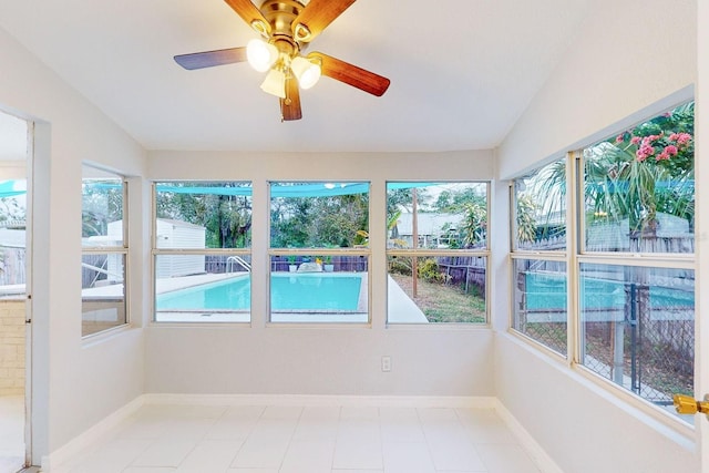 unfurnished sunroom with ceiling fan and vaulted ceiling