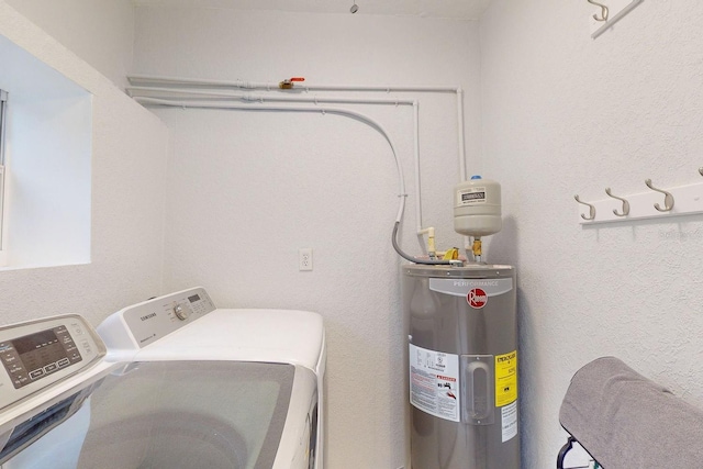 laundry room featuring electric water heater and separate washer and dryer