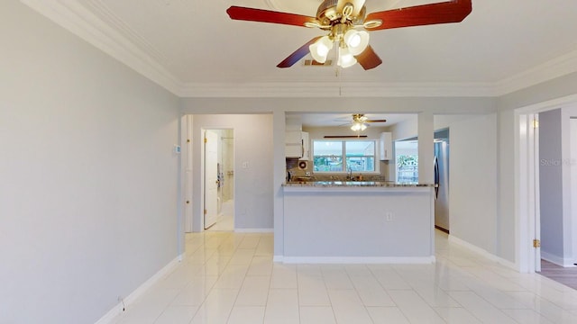 kitchen with light stone countertops, kitchen peninsula, ornamental molding, stainless steel fridge, and white cabinetry