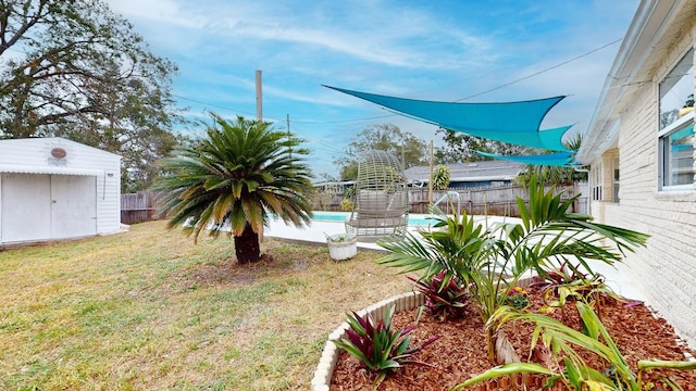 view of yard featuring a fenced in pool and a storage shed