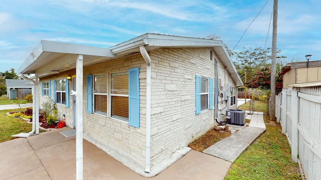 view of side of home with a patio and central air condition unit