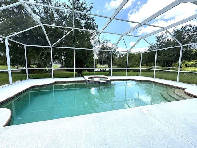 view of swimming pool featuring glass enclosure, an in ground hot tub, and a lawn