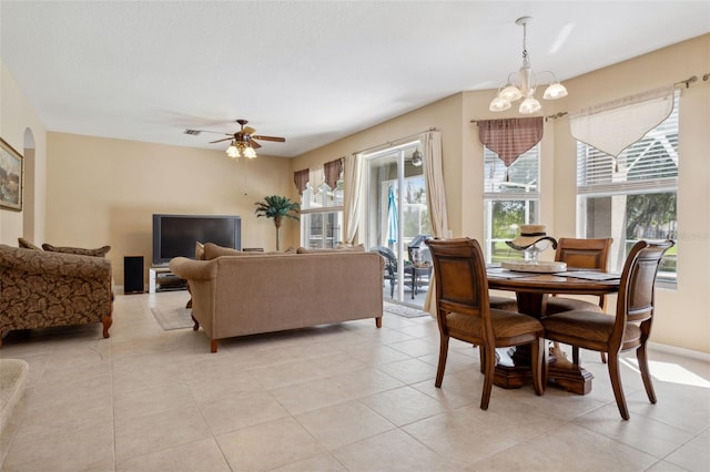 tiled dining room featuring ceiling fan with notable chandelier and plenty of natural light