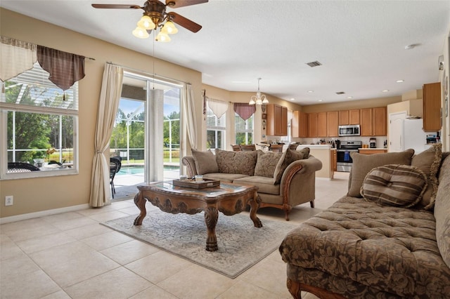 living room featuring ceiling fan with notable chandelier and light tile patterned flooring