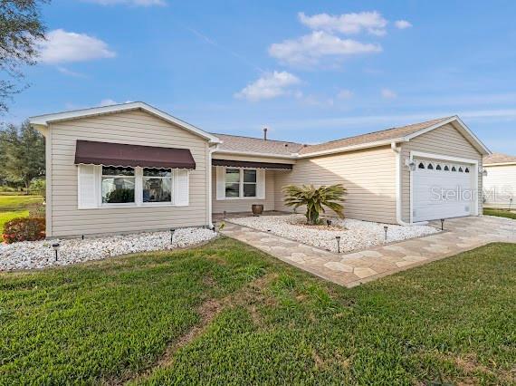 single story home with a garage and a front lawn