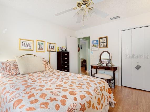 bedroom featuring ceiling fan, a closet, and light wood-type flooring